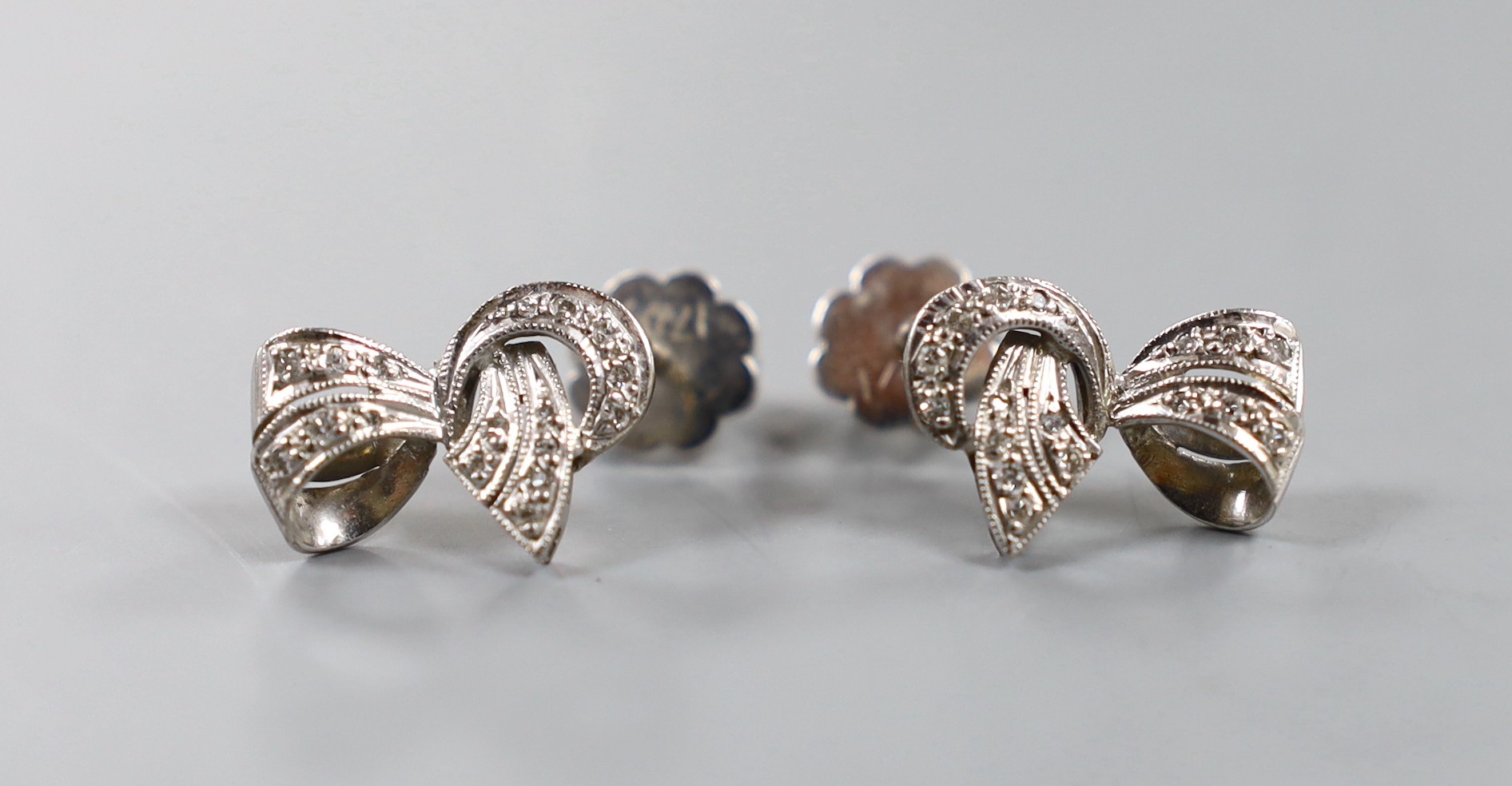 A modern pair of 18ct white gold and diamond chip set scroll earrings, 17mm, gross weight 6.8 grams.